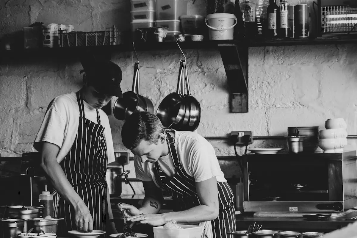 Muncitori asiatici restaurante lucrând concentrat în bucătărie