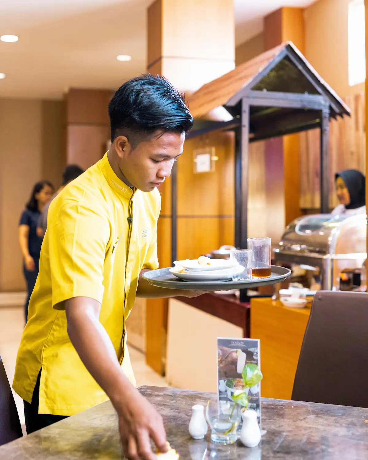 Ospătară din Asia servind în restaurantul hotelului din Moldova