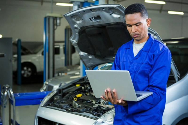 Personal service auto din Asia reparând un automobil